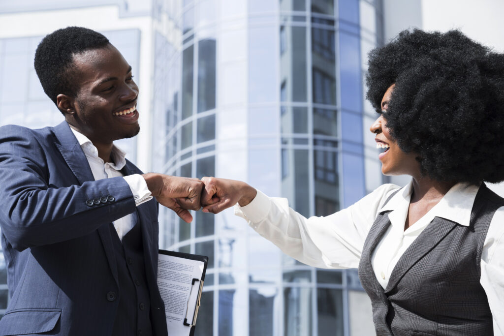 Businessman Businesswoman Bumping Their Fist Front Corporate Building 1 1024x683